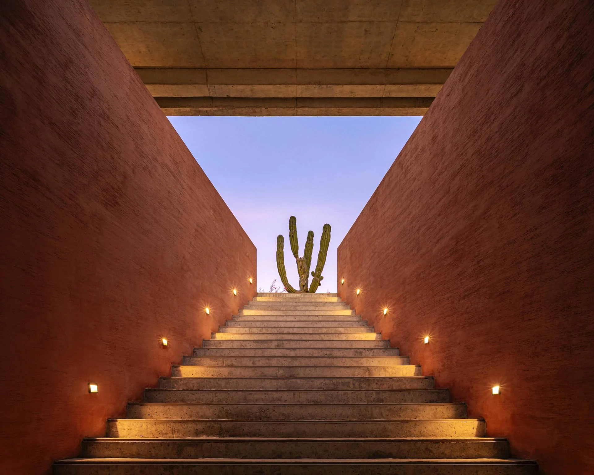 Warm clay stairway lit at dusk leading up through the Las Arenas community in Cabo San Lucas